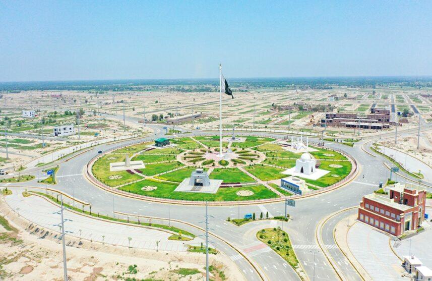 Aerial view of DHA Multan in Pakistan, showcasing a well-planned residential community with wide roads, lush green spaces, and modern infrastructure under a clear sky.