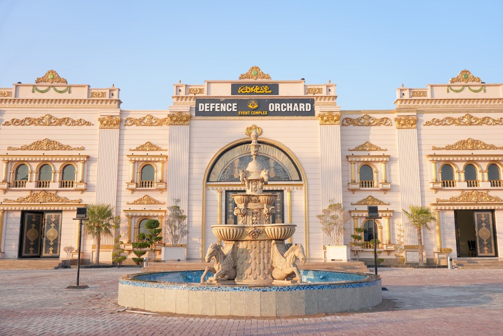 A scenic view of Defence Orchard in DHA Multan, featuring lush green orchards, well-maintained pathways, and a serene environment under a clear sky.